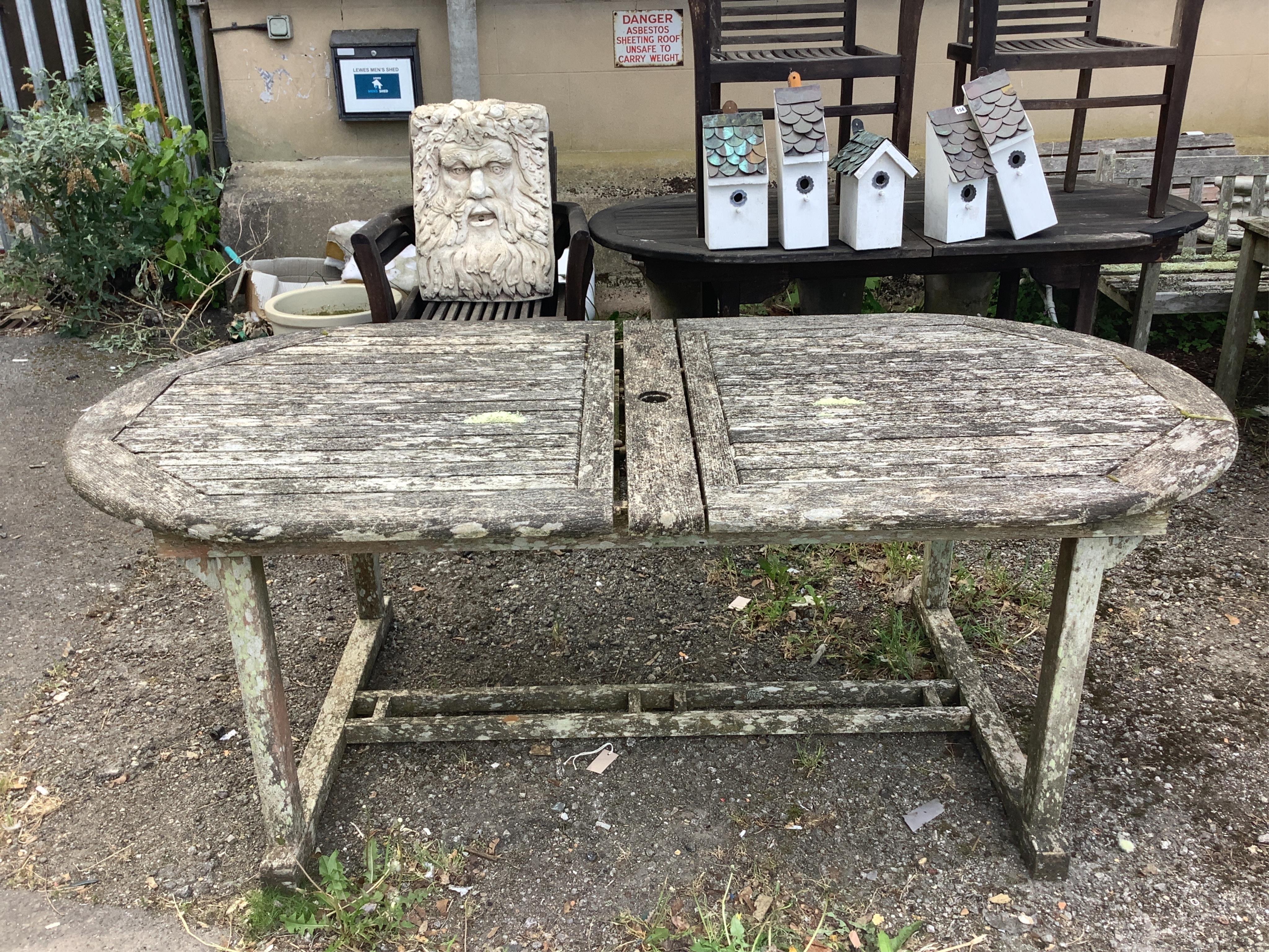 A weathered teak extending garden table, width 260cm extended, depth 99cm, height 72cm